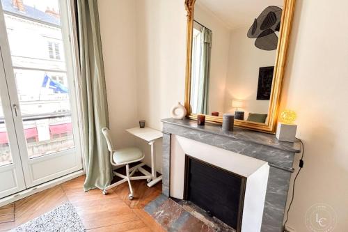 a living room with a fireplace and a mirror at La Cathédrale - 47 m2 - 1 bedroom in Orléans