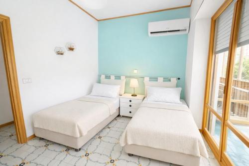 two beds in a room with blue walls at Sorrento Home Pool family BIG appartament in Sorrento center in Sorrento