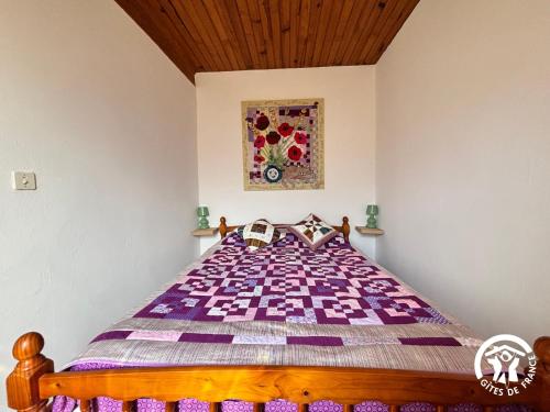 a bedroom with a bed with a purple comforter at La Chambre des Tours in Biran