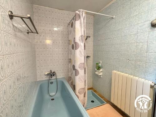 a bathroom with a blue tub and a shower at La Chambre des Tours in Biran