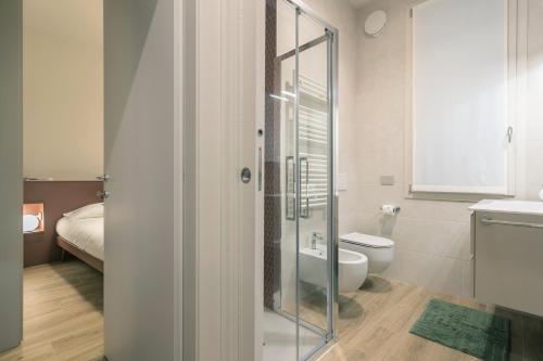 a bathroom with a glass shower and a toilet at GuestHost - Vivaldi Autunno Apartment in Treviglio