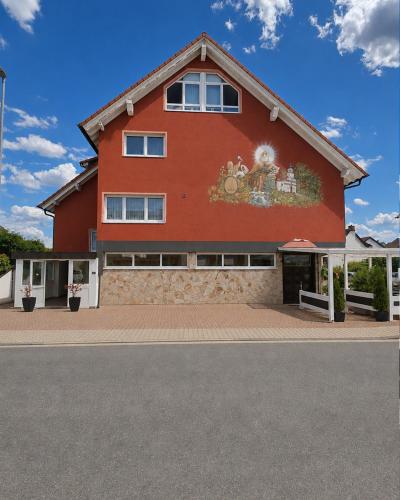 a red building with a mural on the side of it at Hotel Weinhaus Wiedemann in Ginsheim