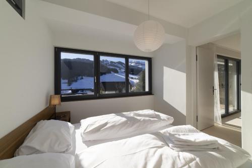 ein Schlafzimmer mit zwei weißen Betten und einem Fenster in der Unterkunft Alpstein in Wildhaus