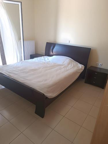 a bed in a room with a bed frame at Gialova Relax in Korifásion