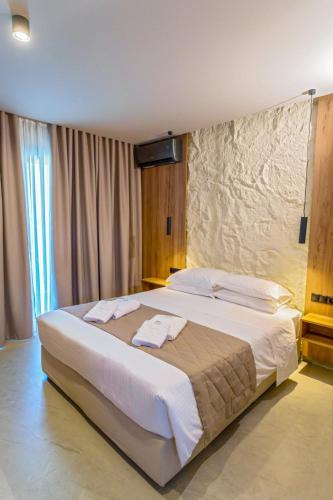 a bedroom with a large bed with white sheets at Filian Apartments in Neos Marmaras