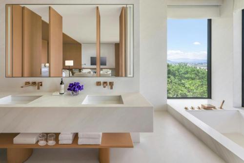 a bathroom with two sinks and a large mirror at The Dali EDITION in Dali