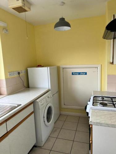 a kitchen with a refrigerator and a washing machine at Budget Central Birmingham in Birmingham