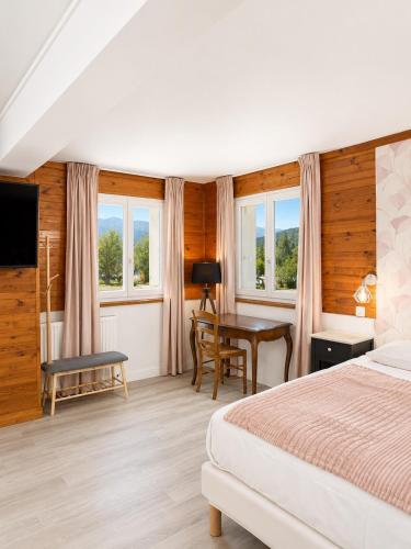 a bedroom with a bed and a desk and a table at Le Napoléon in Corps