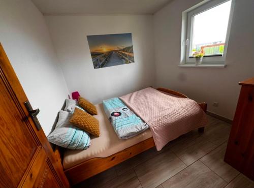 a small bedroom with a bed with pillows on it at Domkiuweroniki in Mielenko