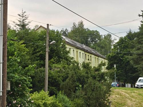a yellow building with a lot of trees at 3-room vacationapartm Sax Switzerland very basic in Lauterbach