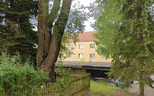 a building with a fence in front of a tree at 3-room vacationapartm Sax Switzerland very basic in Lauterbach