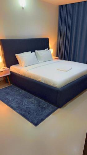 a bed in a room with a blue curtain at The Abode in Lekki Phase 1