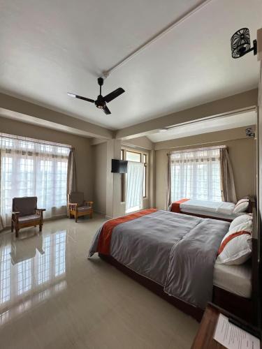 a bedroom with a bed and a ceiling fan at Tre Lum Homestay in Jowai