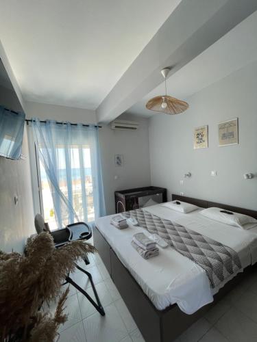 a bedroom with two beds and a large window at Thalassa apartments in Marathias