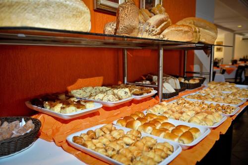 a buffet of bread and pastries on a table at Hotel Rafain Centro in Foz do Iguaçu