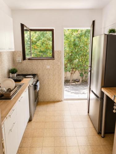 a kitchen with a refrigerator and a door to a yard at W beach house in Buljarica