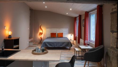 a bedroom with a bed and a table and chairs at La Salamandre Enchantée in Louzac - Saint-André