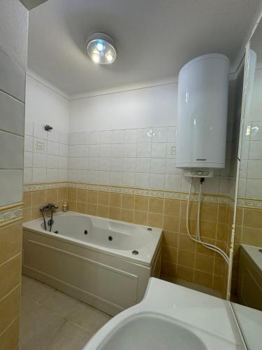 a bathroom with a tub and a toilet and a sink at Seabreeze T3 in Carvoeiro