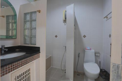 a bathroom with a toilet and a sink at Chalong Pool Courtyard in Ban Na Bon