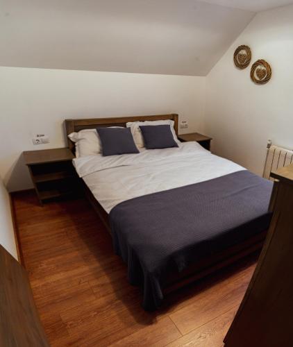 a bedroom with a large bed with blue pillows at Casa Om Bun in Beclean