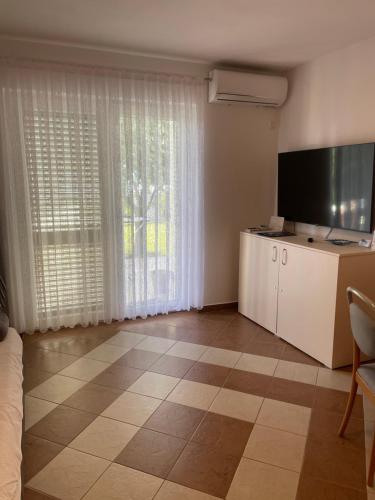 a living room with a large window and a television at Na-Vi in Novi Vinodolski