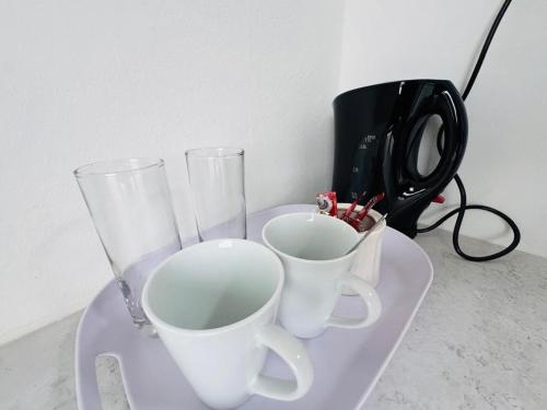 two glasses and two cups on a tray at Carlo's Fairview Boutique - Hotel in Walvis Bay