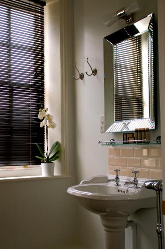 a bathroom with a sink and a mirror and a window at The Bridge House in Ross on Wye