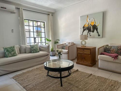 ein Wohnzimmer mit Sofa und Tisch in der Unterkunft Sunbirds Lodge Chobe in Kasane