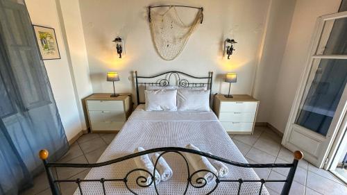 a bedroom with a bed with two night stands and two windows at Katias Villa in Alonnisos