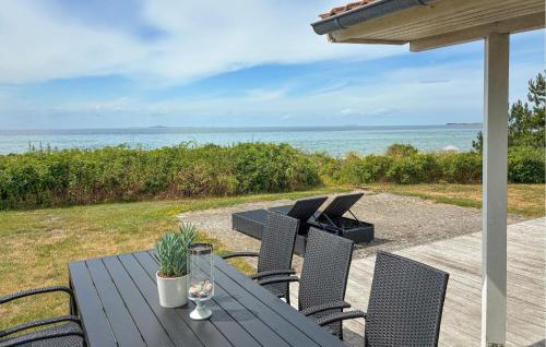a wooden table and chairs with a view of the ocean at Awesome Home In Gørlev With Wifi in Gørlev