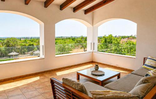 a living room with a couch and two windows at Sa Tanqueta De Calonge in Santanyi
