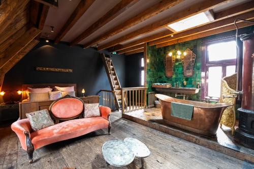 a room with a bathtub and a chair and a room with a bathroom at Royal Suites - Salon de Franz in Amsterdam