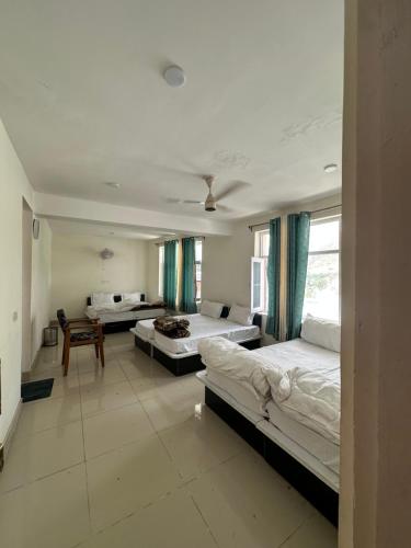 a large room with two beds and a table at Hotel The Kargil Castle in Kargil