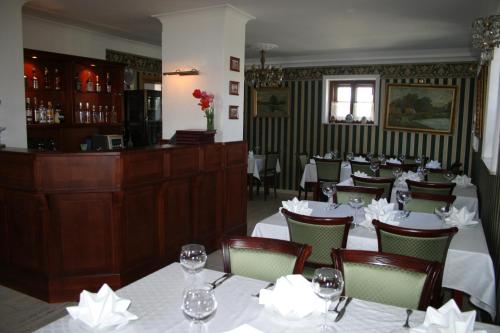 a restaurant with white tables and chairs and a bar at Fisherman's House in Ustka