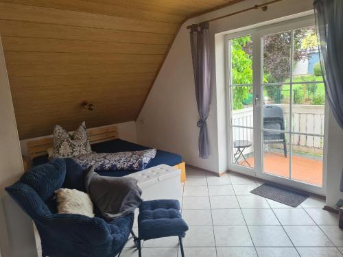 a living room with a couch and a sliding glass door at Im Gottesgarten am Obermain in Zapfendorf