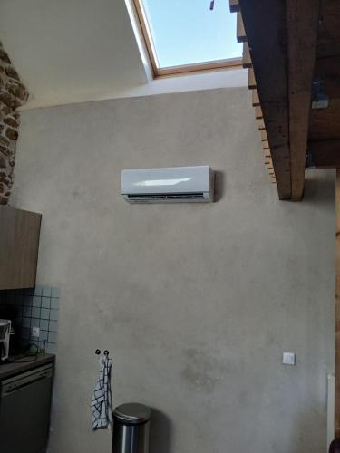 a kitchen with a air conditioner on the wall at Gite Happy Sun Flower in Virlet
