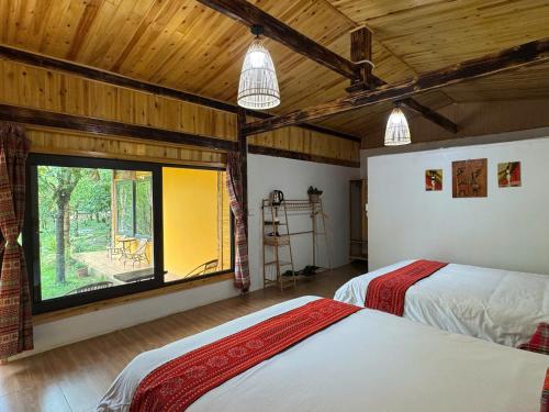 a bedroom with two beds and a large window at The Link farmstay in Sa Pả