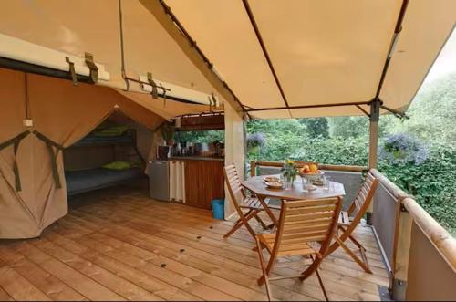a patio with a table and chairs on a deck at Domaine de Montaut in Montaut-Ariège