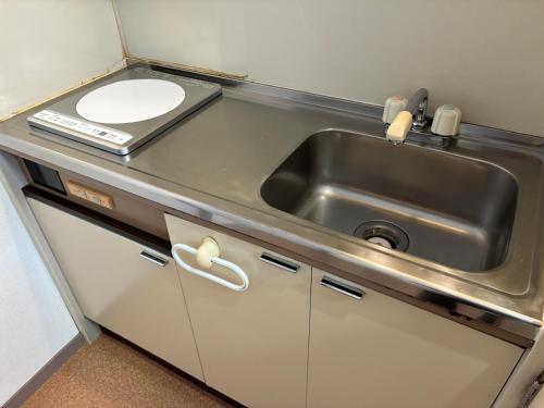 a small kitchen with a sink and a toilet at apartment hotel myu in Mito