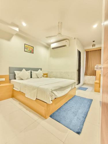 a bedroom with a large bed with a blue rug at Hotel Royal Relax in Gandhinagar