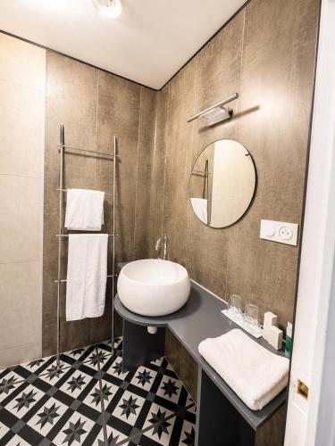 a bathroom with a sink and a mirror at Le Napoléon in Corps