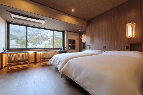 a bedroom with two beds and a large window at Nanaeyae in Nikko