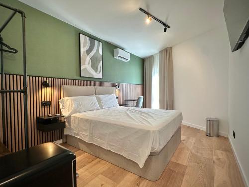 a bedroom with a bed and a green wall at Akasa Rooms Estación in Alicante