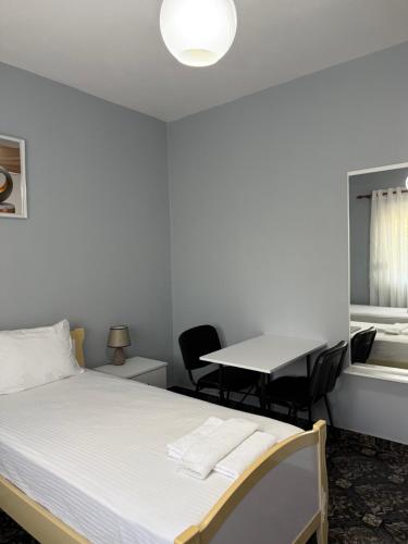 a bedroom with a bed and a table with chairs at Rezidenca Inspire in Tirana