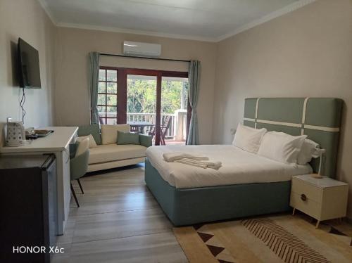 a bedroom with a bed and a living room at Katberg Hotel & Mountain Resort in Karberg