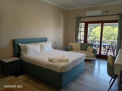 a bedroom with a bed with a chair and a couch at Katberg Hotel & Mountain Resort in Karberg