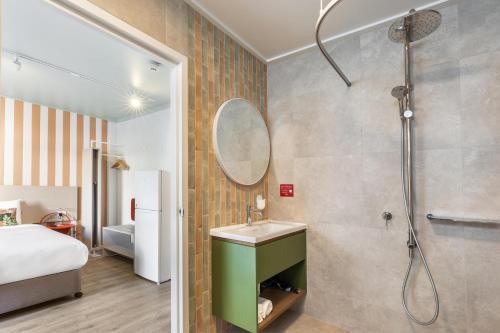 a bathroom with a shower and a sink and a mirror at Nightcap at the Cavenagh in Darwin