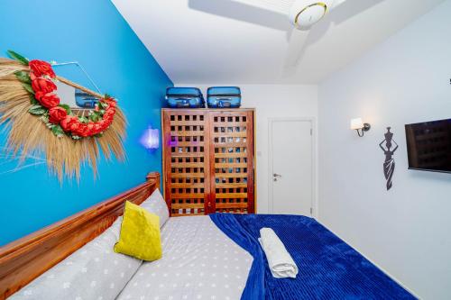 a bedroom with a bed and a blue wall at Zanzibar,Fumbatown Cozy 1 bed Apartment in Fumba