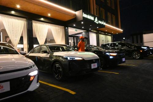 a man standing in front of parked cars in a parking lot at فندق امان أبها - المعالي in Abha