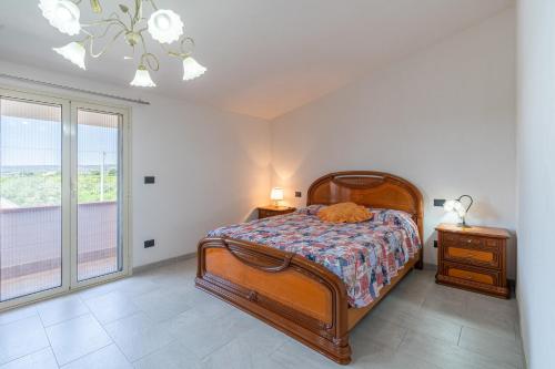 a bedroom with a bed and a large window at Villa Caterina in Solarino